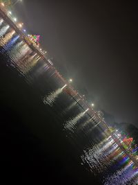 Low angle view of illuminated city against sky at night