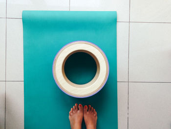 Low section of woman standing on exercise mat