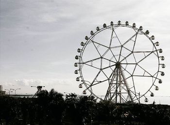 Low angle view of ferris wheel against sky