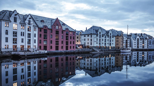 Reflection of buildings in canal against sky