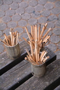 High angle view of bamboo sticks in containers on table