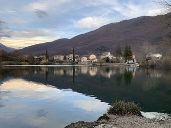 Scenic view of lake by buildings against sky