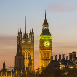 Buildings in city against sky during sunset