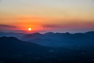 Scenic view of silhouette mountains against romantic sky at sunset