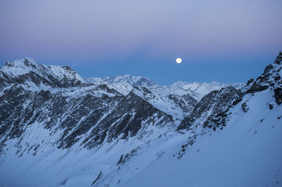 Scenic view of snowcapped mountains against clear sky at night