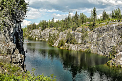 Scenic view of lake by trees against sky