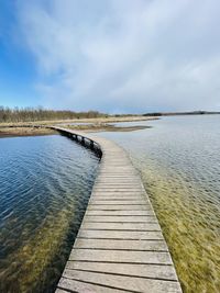 Pier over lake against sky