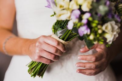 Cropped image of hand holding purple flower