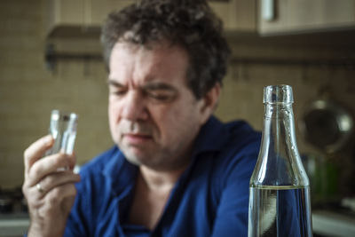 Close-up portrait of a man drinking glass