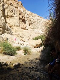 People on cliff against sky