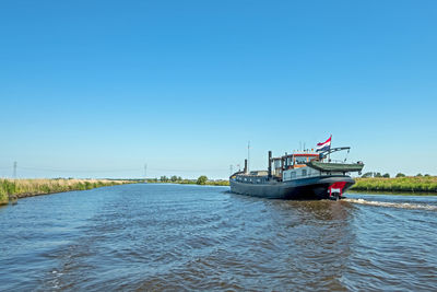 Freighter on the frisian canals in friesland the netherlands
