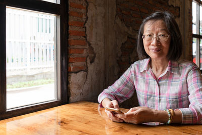 Portrait of woman sitting on table at home