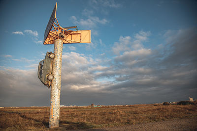 Low angle view of cross on field against sky