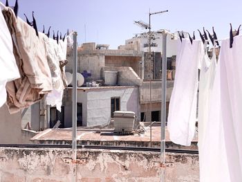 Low angle view of clothes drying on clothesline against buildings