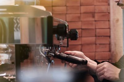 Midsection of barista preparing coffee at cafe