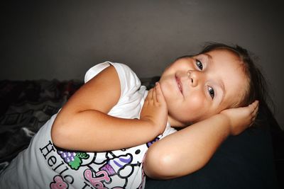 Portrait of cute baby lying on bed at home