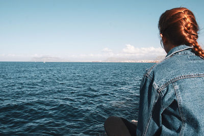 Rear view of woman looking at sea against sky