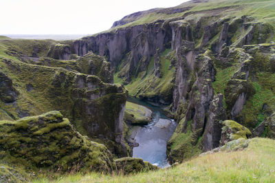 Scenic view of river amidst mountains against sky