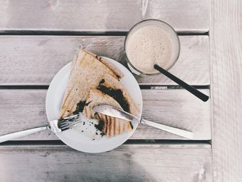 High angle view of quesadilla and milkshake on wooden table