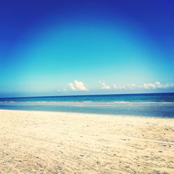 Scenic view of beach against blue sky