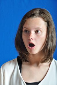 Shocked woman against blue fabric