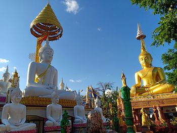 Statue against temple and building against sky