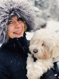 Portrait of woman with dog in winter