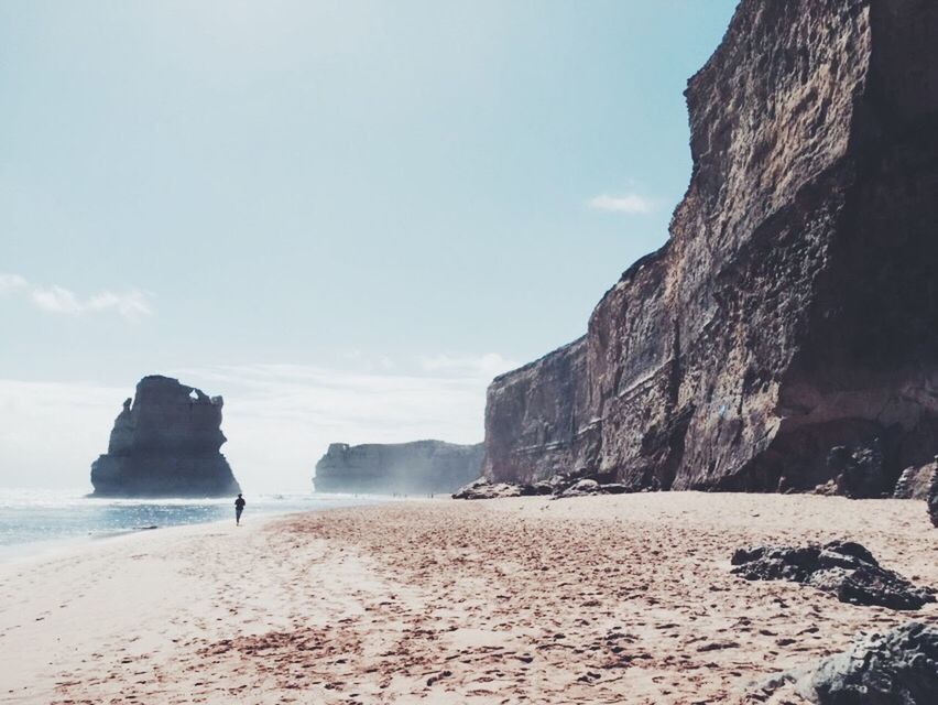 sea, beach, rock formation, tranquil scene, tranquility, shore, rock - object, sand, sky, scenics, water, beauty in nature, nature, horizon over water, rock, cliff, coastline, idyllic, remote, sunlight