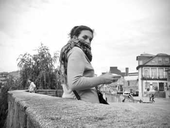 Portrait of woman with umbrella against sky in city