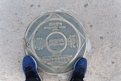 Low section of person standing by text on floor