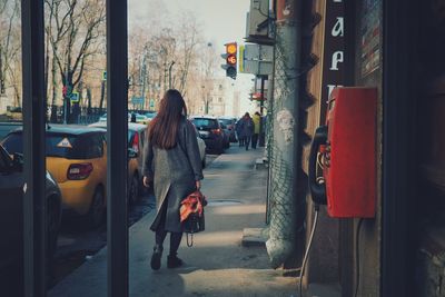 Rear view of woman walking on street in city