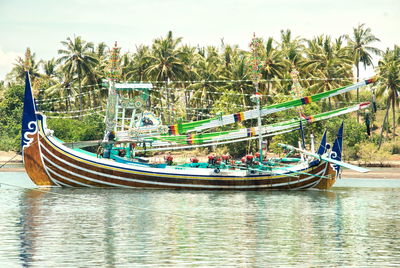 Boats moored in river against sky