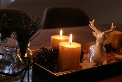 Close-up of burning candles on table