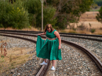 Woman standing on railroad tracks