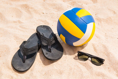 High angle view of flip-flops and ball on beach