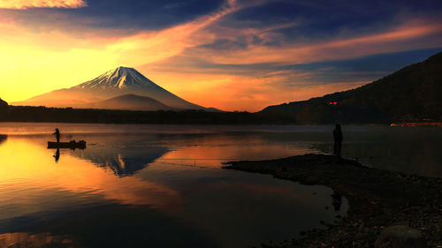 Scenic view of lake and mount fuji against sky during sunset