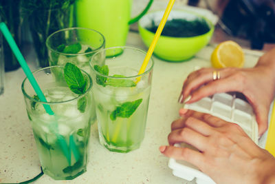 Cropped image of hand holding drink on table