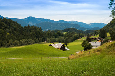 Scenic view of green landscape and mountains against sky