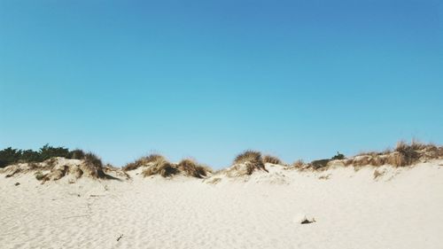 Scenic view of desert against clear blue sky