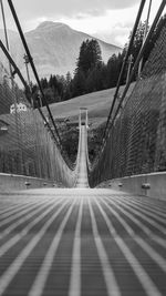 Empty road by bridge against sky