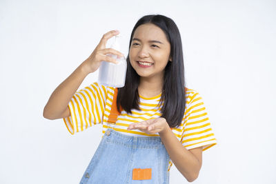 Portrait of a smiling young woman against white background