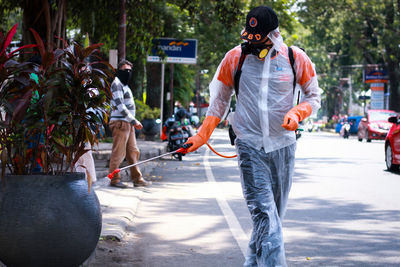 Rear view of people walking on road in city