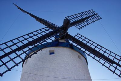 Low angle view of windmill against clear blue sky