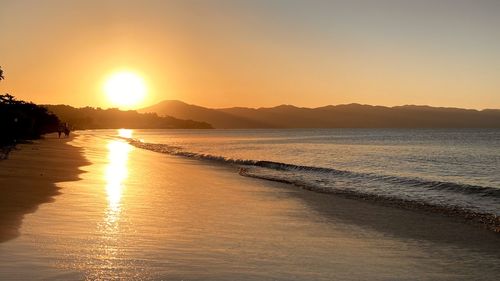 Scenic view of beach against sky during sunset