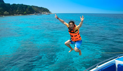 Full length portrait of man jumping in sea