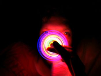 Close-up of person holding multi colored lights