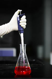 Cropped hand of scientist wearing surgical glove while working in laboratory