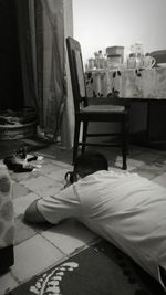 Rear view of man relaxing on bed at home