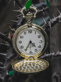 Close-up of clock hanging on metal