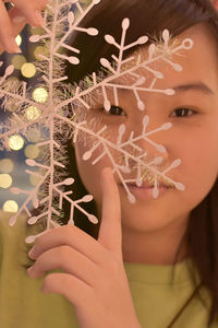 Close-up portrait of woman holding christmas tree